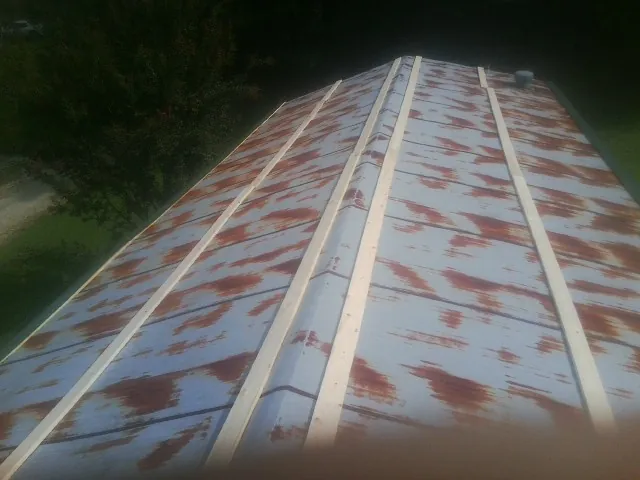 Rusted metal roof panels with new wood purlins before replacement — Storm Damage Roof Repair in Central Bridge by Roofing Brothers